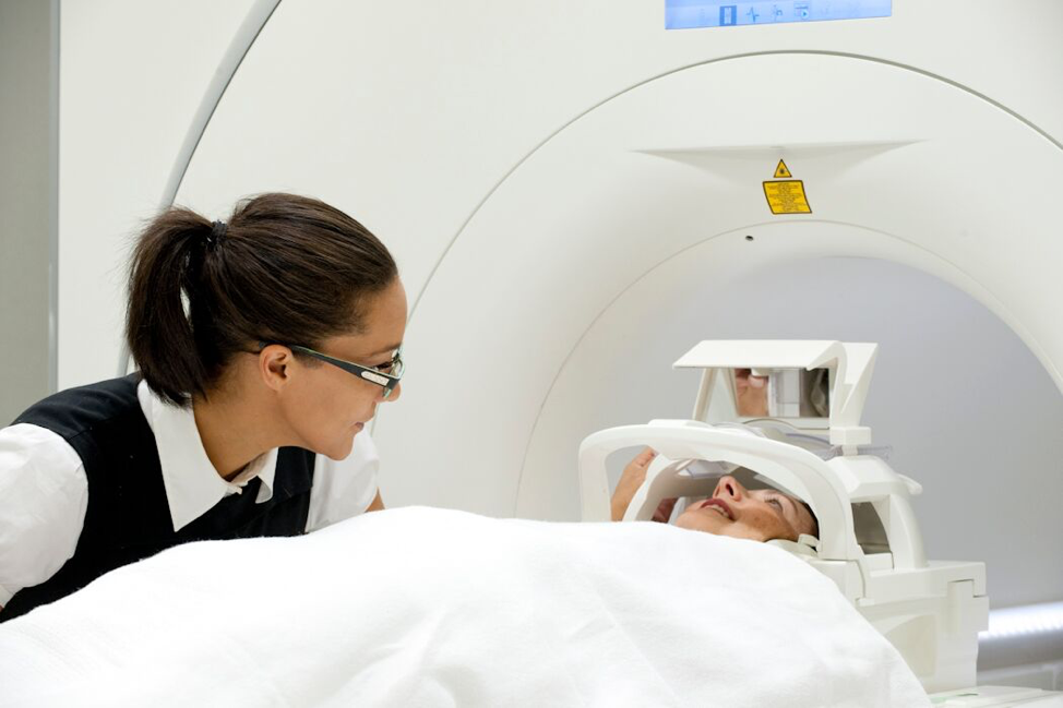 Woman assisting a participant into an MRI scanner